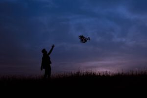 Mann auf einer Wiese am Abend